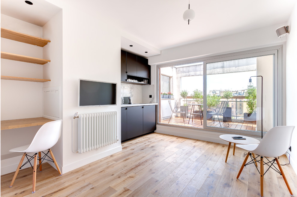Свежая идея для дизайна: маленькая открытая гостиная комната в современном стиле с белыми стенами, светлым паркетным полом и телевизором на стене для на участке и в саду - отличное фото интерьера
