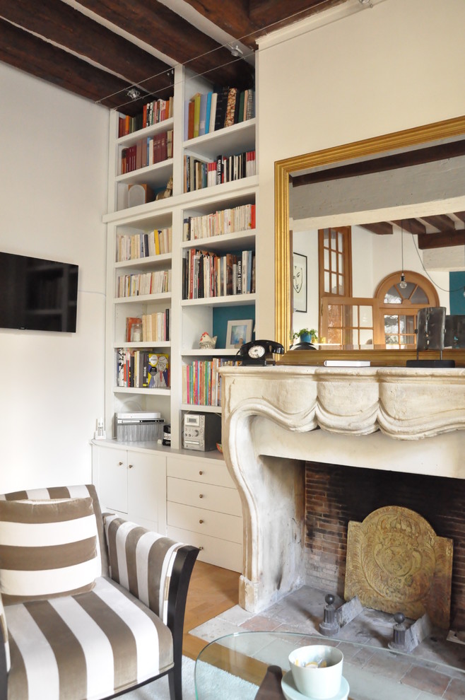 Стильный дизайн: большая открытая гостиная комната в стиле фьюжн с с книжными шкафами и полками, белыми стенами, паркетным полом среднего тона и телевизором на стене - последний тренд