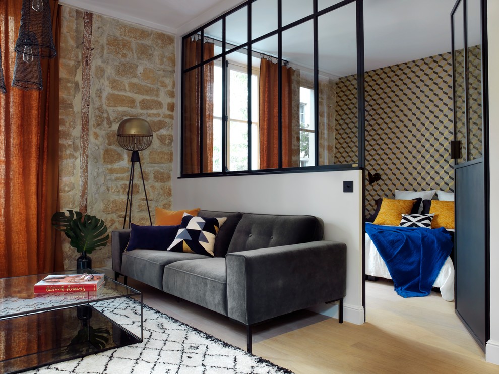 Mittelgroßes, Fernseherloses Modernes Wohnzimmer ohne Kamin mit hellem Holzboden in Paris