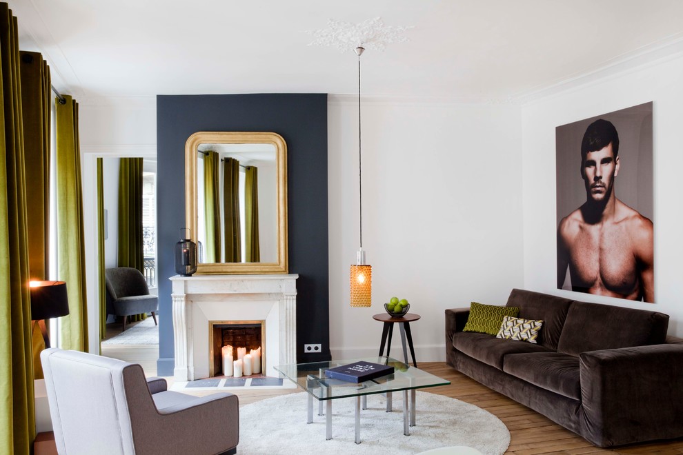 Medium sized contemporary enclosed living room in Paris with white walls, light hardwood flooring, a standard fireplace, a stone fireplace surround and no tv.