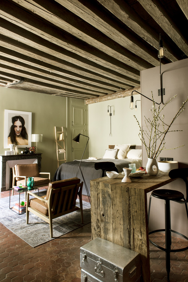 Photo of a small eclectic open plan games room in Paris with grey walls, terracotta flooring, no tv, red floors, a standard fireplace and a concrete fireplace surround.