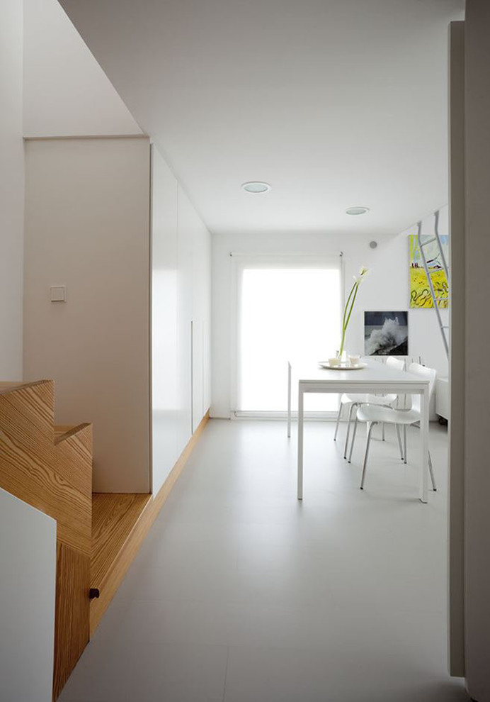 Cette photo montre une grande salle de séjour moderne ouverte avec un mur blanc, sol en béton ciré, aucune cheminée, aucun téléviseur et un sol gris.