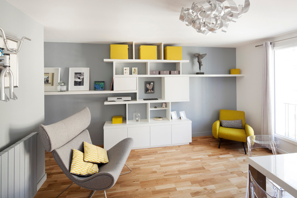 Immagine di un soggiorno minimal di medie dimensioni e aperto con pareti grigie, parquet chiaro e nessun camino