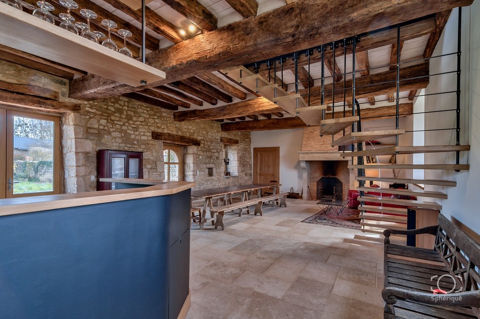 Inspiration for a large country open plan games room in Angers with a home bar, beige walls, limestone flooring, a standard fireplace, a stone fireplace surround and no tv.