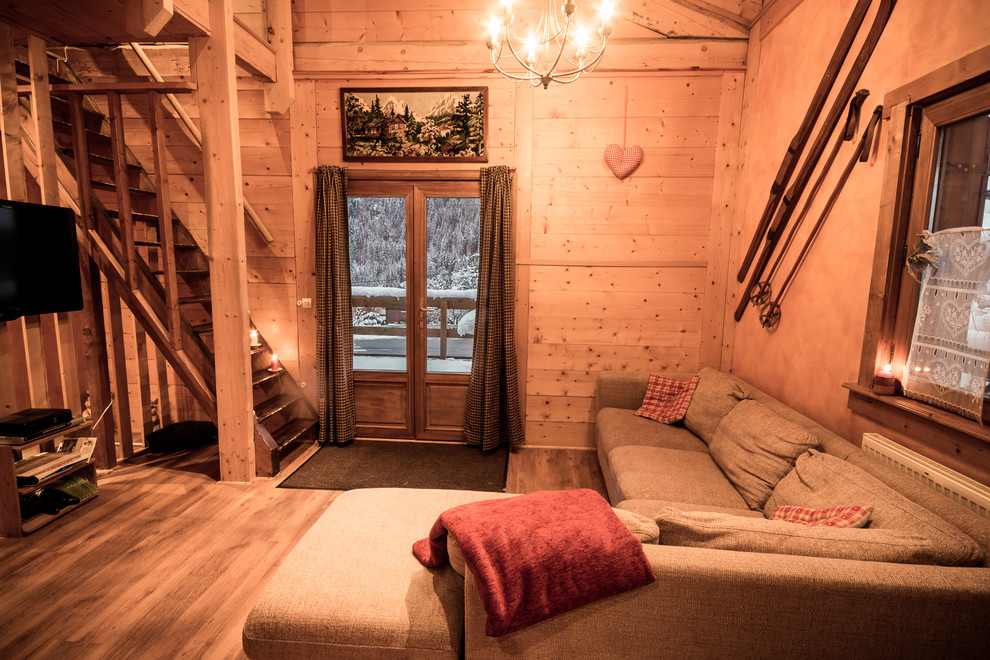 Immagine di un ampio soggiorno rustico stile loft con pareti beige, parquet chiaro, nessun camino e TV a parete