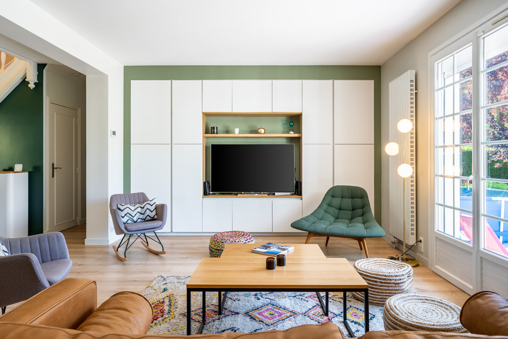 Modelo de sala de estar abierta escandinava grande con paredes verdes, suelo de madera clara, estufa de leña y pared multimedia