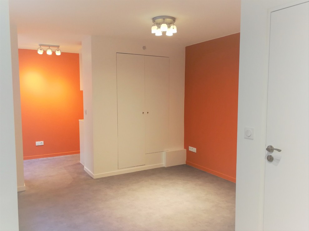 Foto på ett litet funkis avskilt allrum, med orange väggar, vinylgolv och grått golv