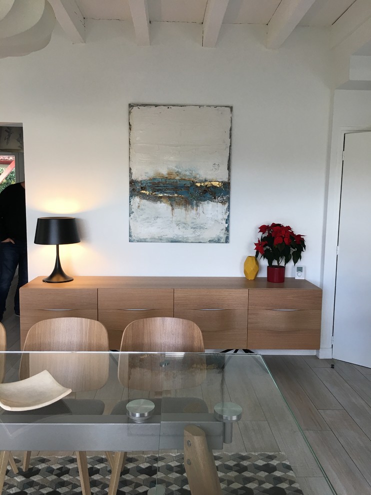 Imagen de sala de estar abierta nórdica grande sin chimenea con paredes blancas, suelo de madera clara, televisor colgado en la pared y suelo beige