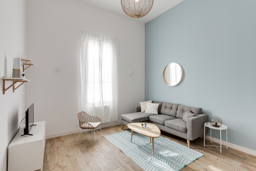Inspiration pour une grande salle de séjour mansardée ou avec mezzanine nordique avec un mur bleu, parquet clair, un sol marron et un plafond décaissé.