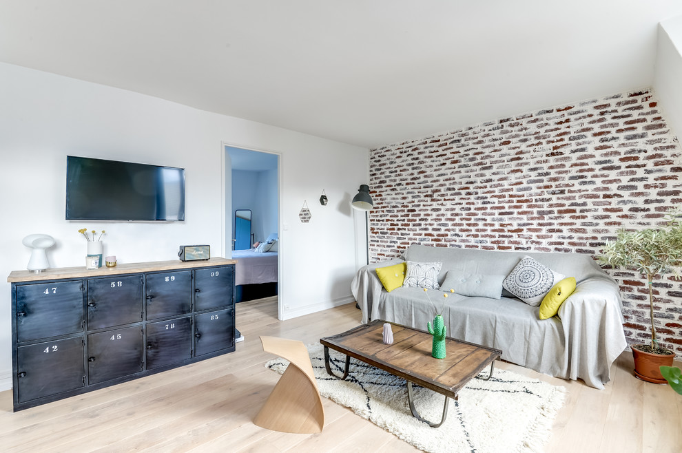 Modelo de sala de estar cerrada contemporánea de tamaño medio sin chimenea con paredes blancas, suelo de madera clara y televisor colgado en la pared