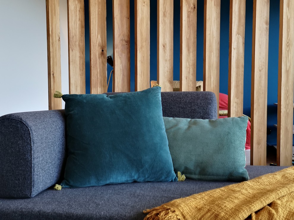 Idée de décoration pour une salle de séjour de taille moyenne et ouverte avec un mur bleu, parquet clair et un sol orange.