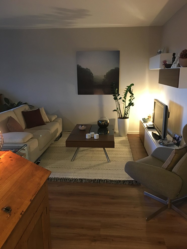 Modelo de sala de estar abierta tradicional renovada pequeña sin chimenea con paredes blancas, suelo de madera oscura y suelo blanco
