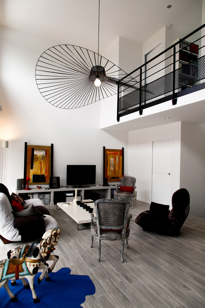 Modelo de sala de estar abierta escandinava extra grande con paredes blancas, suelo de baldosas de porcelana y televisor independiente