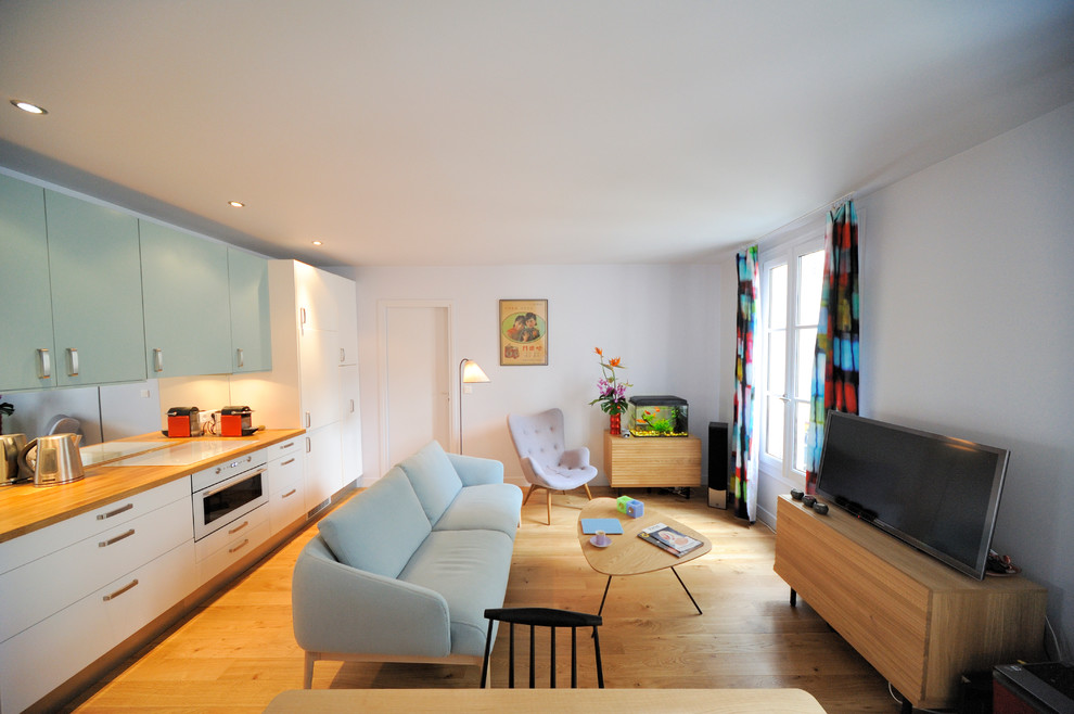Foto di un soggiorno minimal aperto e di medie dimensioni con pareti bianche, pavimento in legno massello medio, nessun camino, TV autoportante e libreria