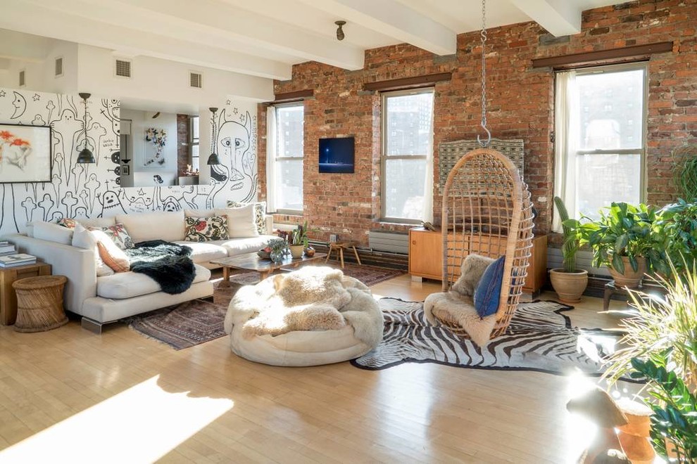 Imagen de sala de estar abierta industrial de tamaño medio con paredes blancas, suelo laminado, televisor colgado en la pared y suelo beige