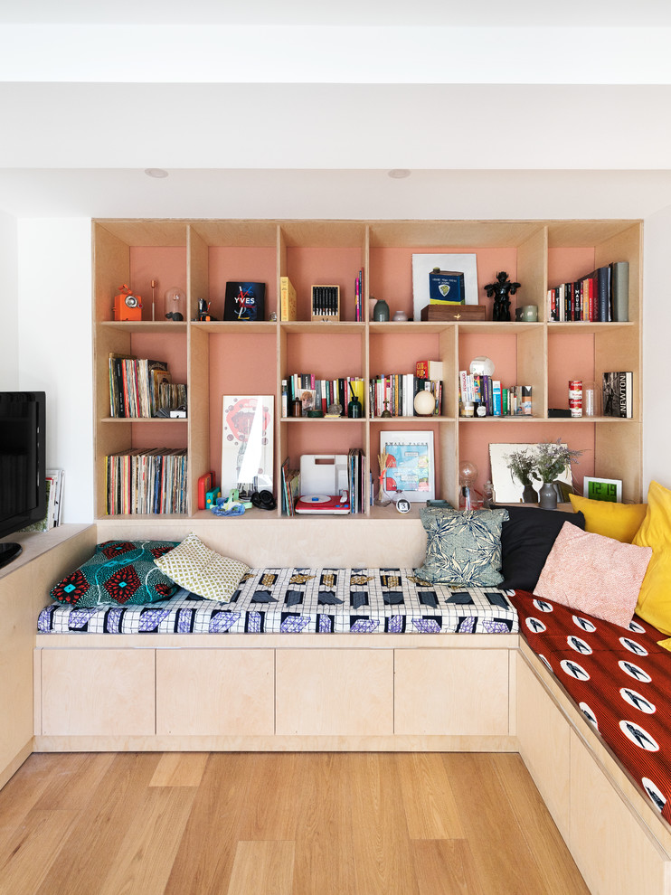 Offene Moderne Bibliothek ohne Kamin mit hellem Holzboden, weißer Wandfarbe, freistehendem TV und braunem Boden in Paris