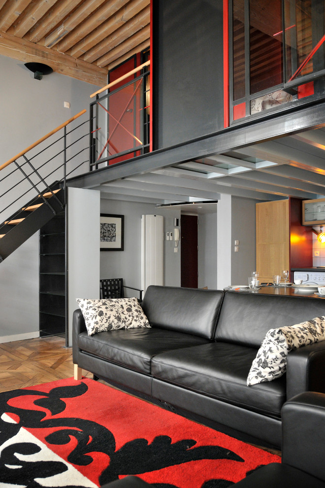 Imagen de sala de estar actual de tamaño medio con paredes grises y suelo de madera en tonos medios