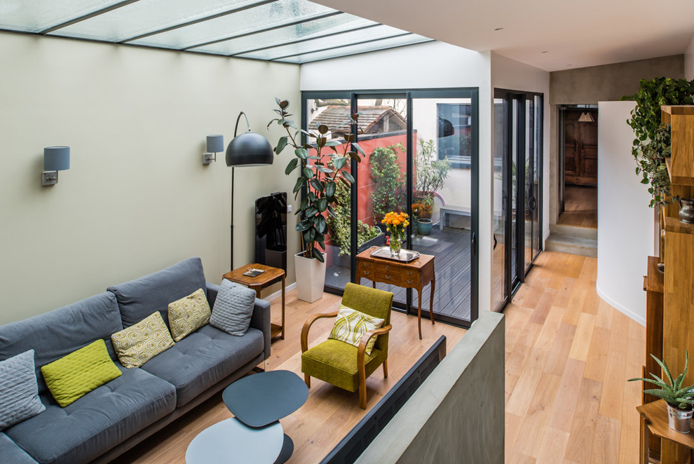Imagen de sala de estar contemporánea pequeña con paredes beige y suelo de madera clara