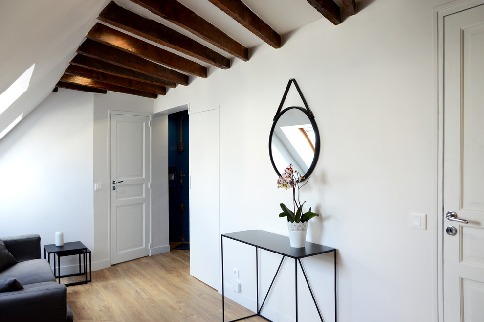 Aménagement d'une petite salle de séjour mansardée ou avec mezzanine contemporaine avec un mur blanc et sol en stratifié.