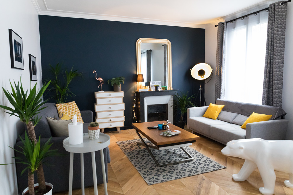 Cette image montre un salon vintage de taille moyenne et ouvert avec un mur bleu, parquet clair, une cheminée standard, un manteau de cheminée en pierre, un téléviseur indépendant et un sol marron.