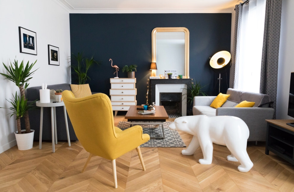 Exemple d'une salle de séjour rétro de taille moyenne et fermée avec un mur bleu, parquet clair, une cheminée standard, un manteau de cheminée en pierre, un téléviseur indépendant et un sol marron.