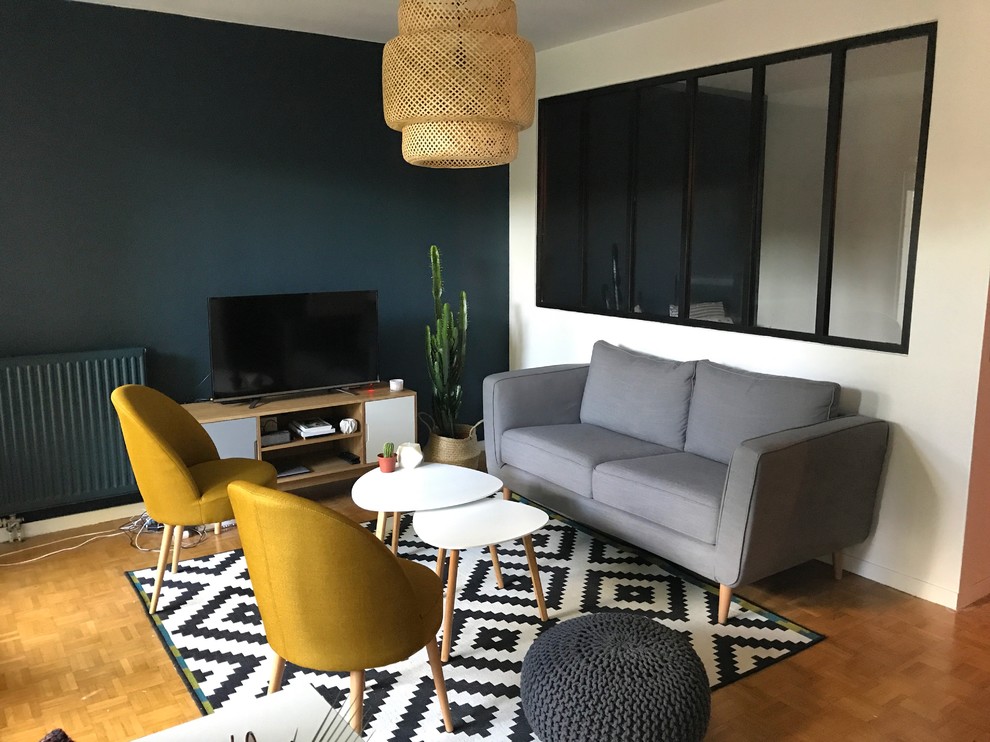Esempio di un soggiorno nordico di medie dimensioni e aperto con pareti blu, parquet chiaro, TV autoportante e pavimento marrone