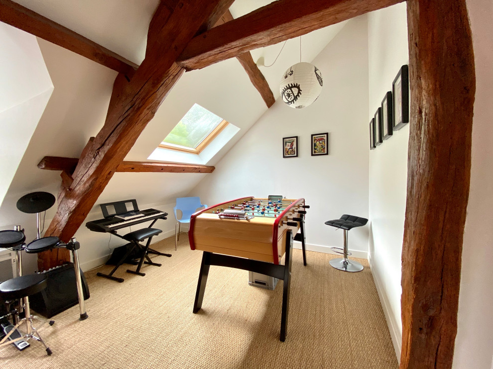 Example of an eclectic carpeted, brown floor, exposed beam and vaulted ceiling game room design in Paris with white walls