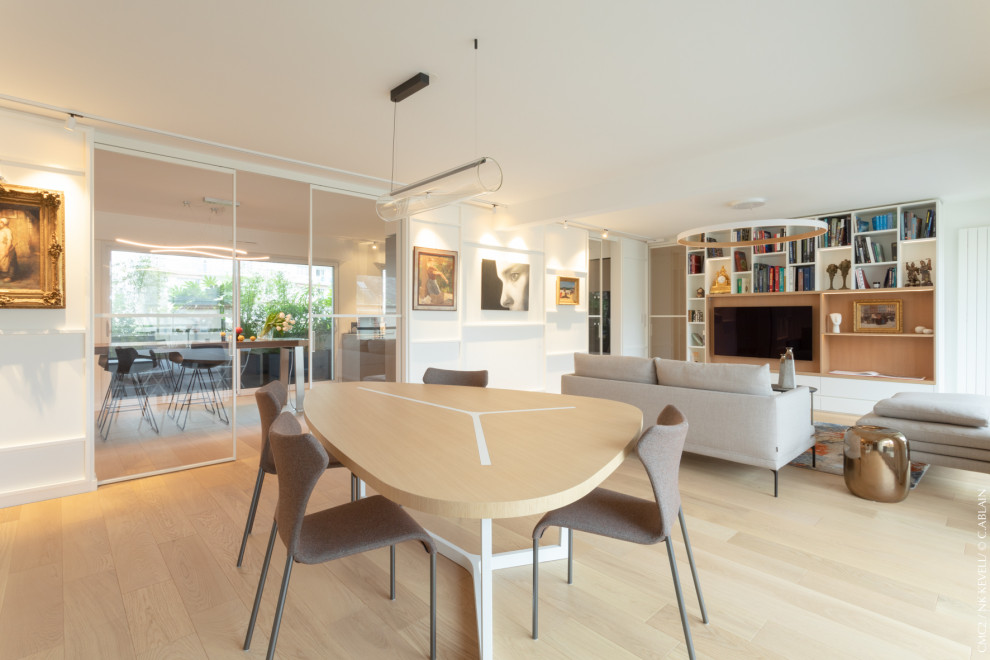 Example of a large trendy open concept light wood floor family room design in Rennes with white walls, no fireplace and a media wall