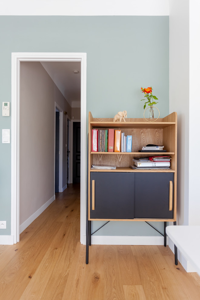 Imagen de sala de estar cerrada nórdica de tamaño medio con paredes azules, suelo de madera clara, televisor independiente y suelo beige