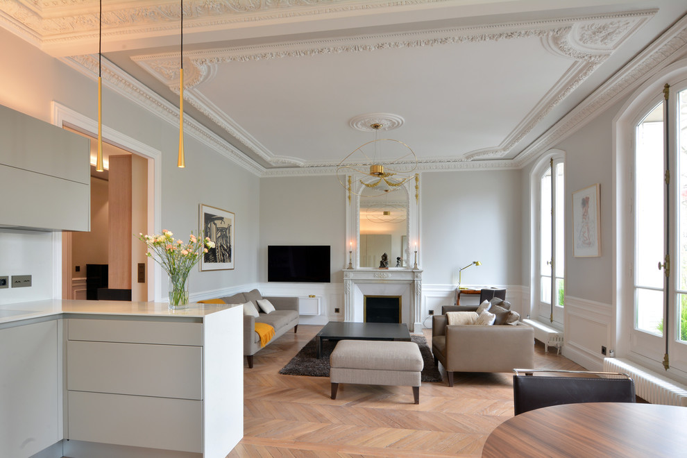 Réalisation d'une grande salle de séjour design ouverte avec un mur blanc, parquet clair, une cheminée standard, un téléviseur fixé au mur et un sol marron.