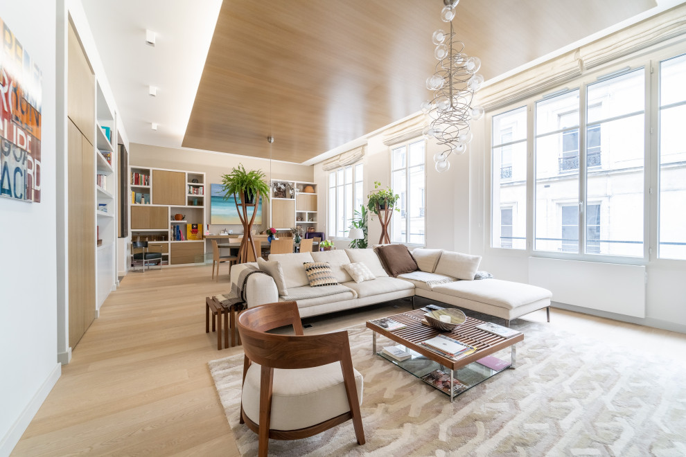 Foto di un grande soggiorno design aperto con soffitto in legno, pareti beige, parquet chiaro, nessun camino, TV autoportante e pavimento beige