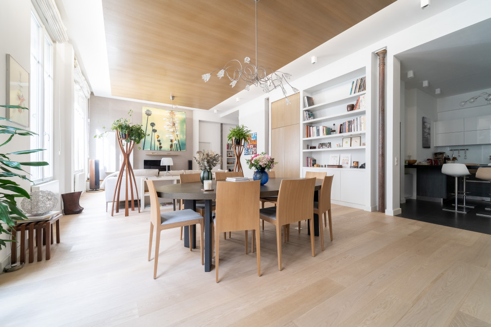 Immagine di una grande sala da pranzo minimal con soffitto in legno, pareti beige, parquet chiaro, nessun camino e pavimento beige