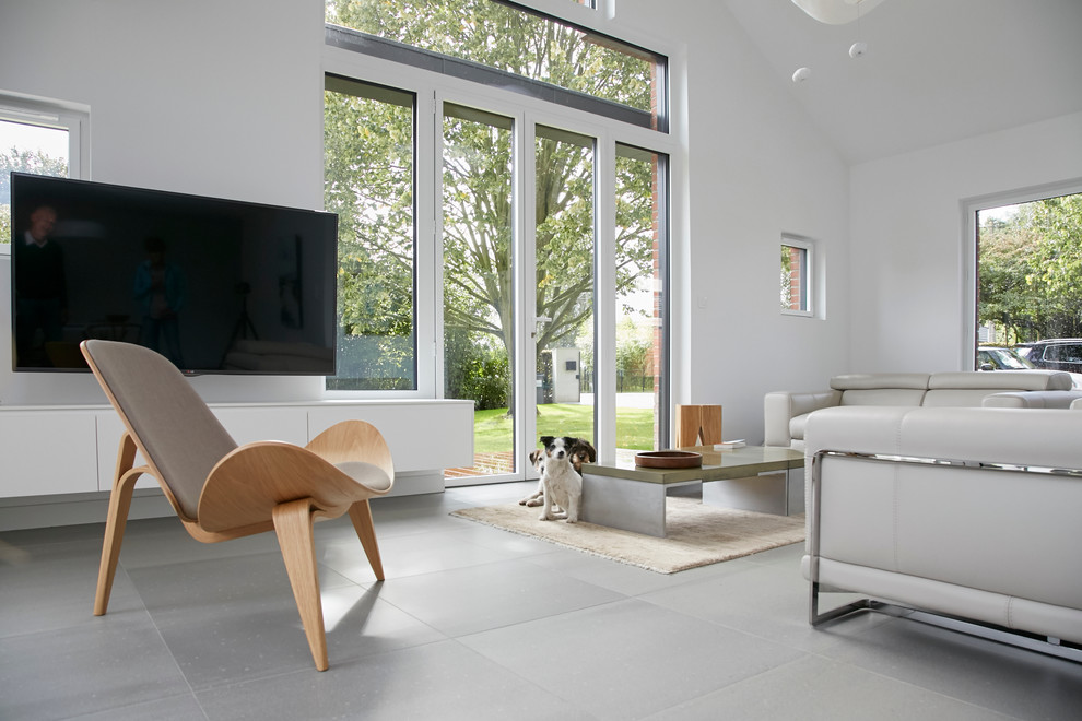 Mittelgroßes, Offenes Nordisches Wohnzimmer ohne Kamin mit weißer Wandfarbe, Keramikboden, TV-Wand und grauem Boden in Lille