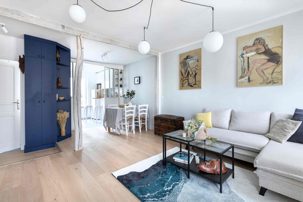 Modelo de sala de estar abierta tradicional de tamaño medio sin chimenea con paredes grises, suelo de contrachapado y suelo beige