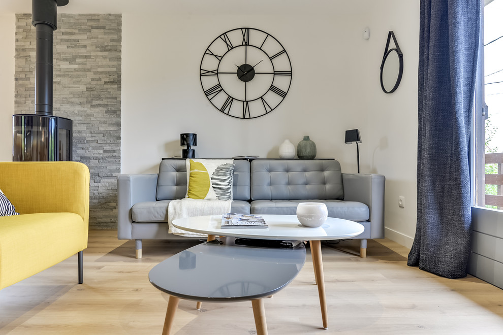 Diseño de sala de estar abierta contemporánea de tamaño medio con paredes blancas, suelo laminado, estufa de leña, suelo beige y marco de chimenea de metal
