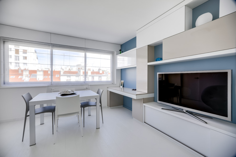 Стильный дизайн: большая открытая гостиная комната в стиле модернизм с синими стенами, деревянным полом, отдельно стоящим телевизором и белым полом без камина - последний тренд