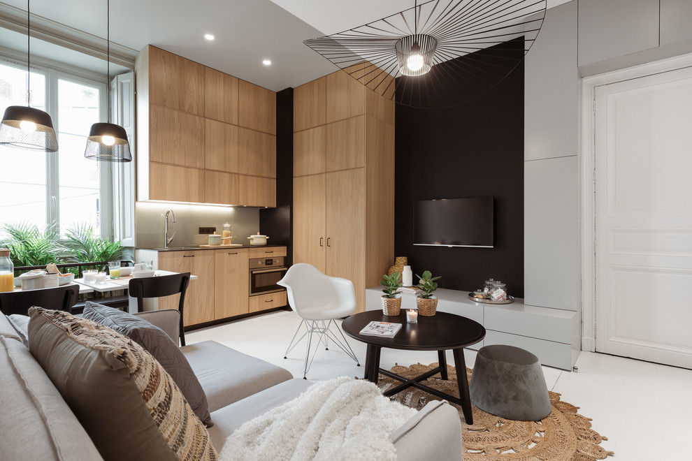 Diseño de sala de estar abierta escandinava sin chimenea con paredes negras, televisor colgado en la pared y suelo blanco