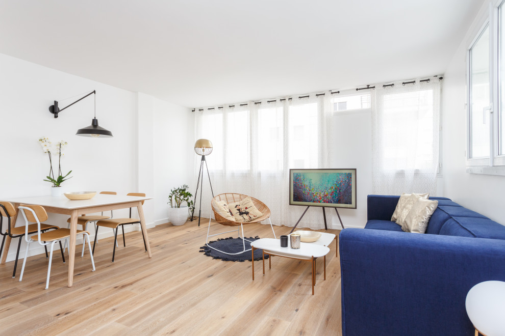 Inspiration pour une salle de séjour design ouverte avec un mur blanc, parquet clair, un téléviseur indépendant et un sol beige.