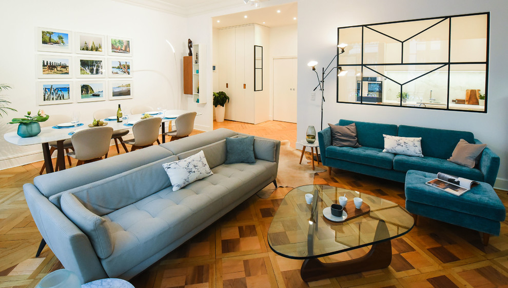 Inspiration pour une grande salle de séjour design ouverte avec un mur gris, parquet clair, une cheminée d'angle, un téléviseur encastré et un sol marron.