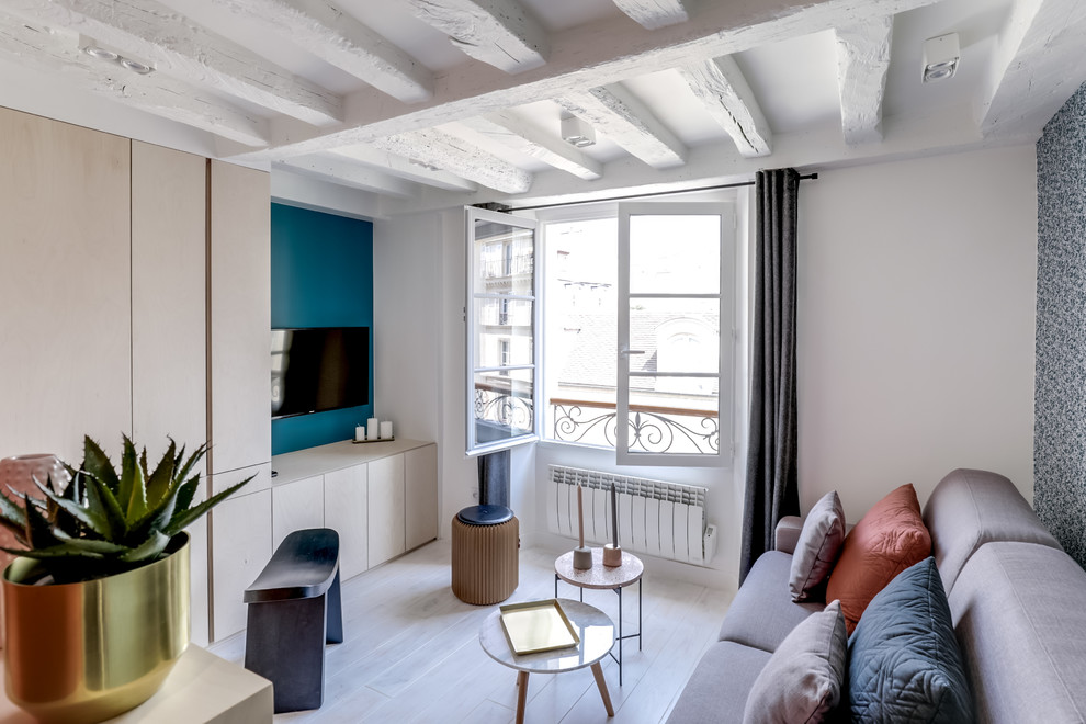 Exemple d'une petite salle de séjour tendance ouverte avec un mur bleu, parquet peint, aucune cheminée, un téléviseur fixé au mur et un sol blanc.
