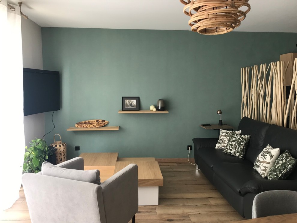 Modelo de sala de estar abierta nórdica grande con paredes verdes y suelo laminado