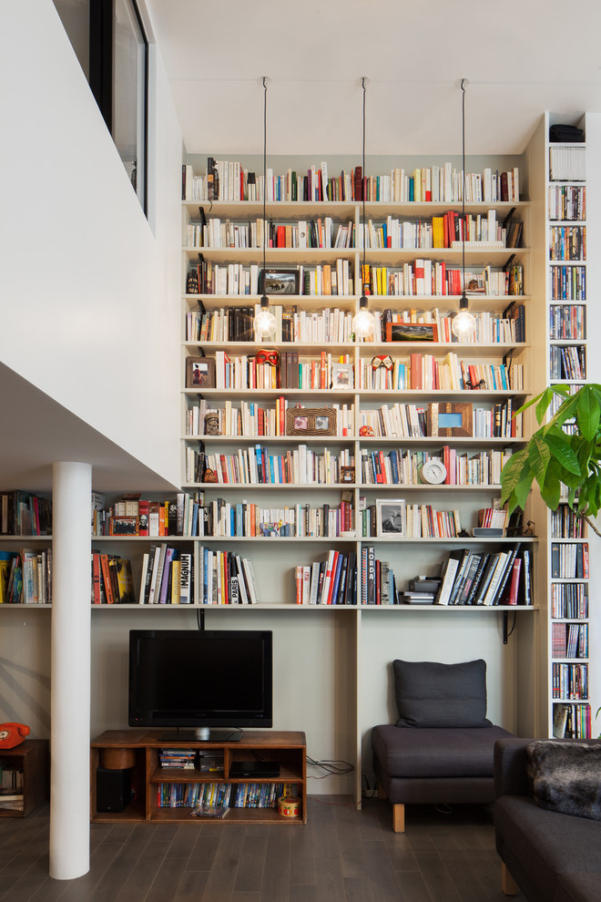 Foto di un grande soggiorno design aperto con libreria, pareti grigie, parquet scuro, nessun camino e TV autoportante