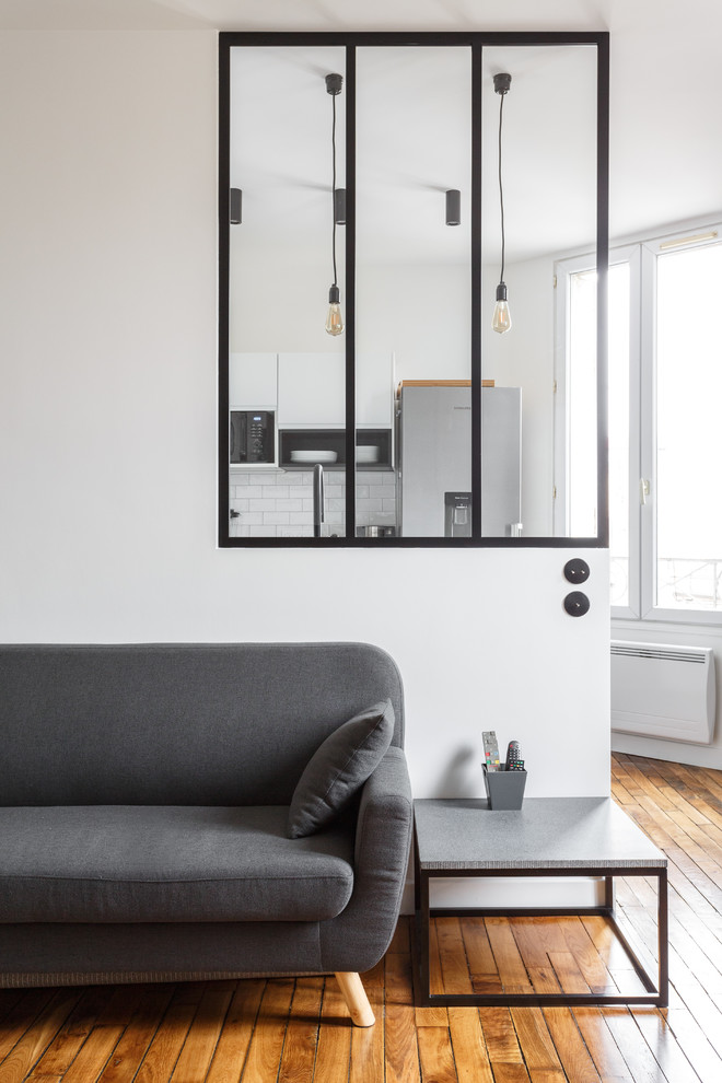 Foto de sala de estar abierta moderna pequeña sin chimenea con paredes blancas, suelo de madera en tonos medios, televisor independiente y suelo marrón