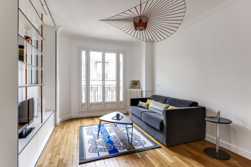 Idee per un piccolo soggiorno minimalista aperto con pareti blu, pavimento in legno massello medio, camino ad angolo e pavimento beige
