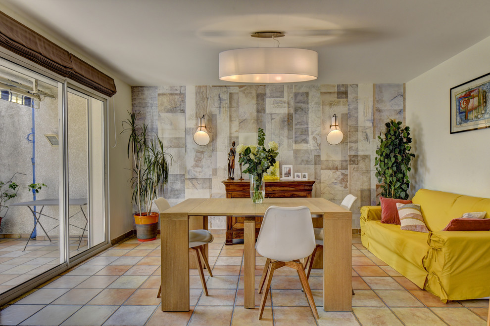 Inspiration pour une grande salle à manger design avec un mur vert, tomettes au sol, une cheminée standard, un manteau de cheminée en métal et un sol marron.