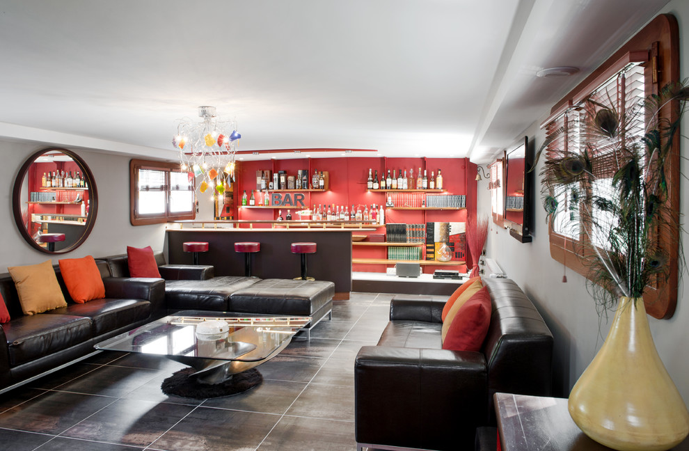 Cette image montre une salle de séjour design fermée avec un bar de salon, un mur rouge et un sol noir.