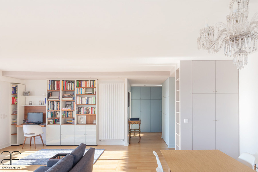 Diseño de sala de estar con biblioteca abierta actual grande con paredes multicolor y suelo de madera clara
