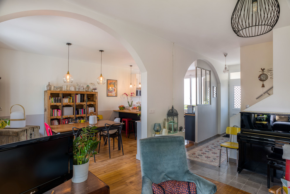 Mittelgroßes, Offenes Industrial Wohnzimmer mit hellem Holzboden, weißer Wandfarbe und freistehendem TV in Paris