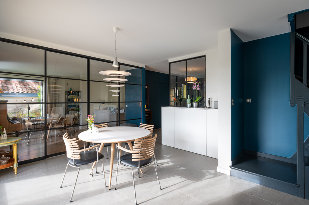 Ispirazione per una sala da pranzo nordica con pareti blu, pavimento con piastrelle in ceramica e pavimento grigio