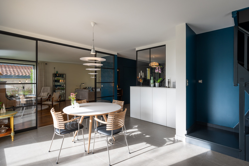 Foto di una sala da pranzo scandinava con pareti blu, pavimento con piastrelle in ceramica e pavimento grigio